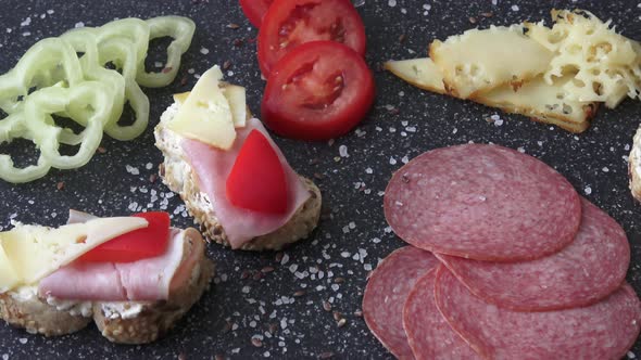 Cold appetizer. Cold cuts. Spicy food on black background. Different snacks 