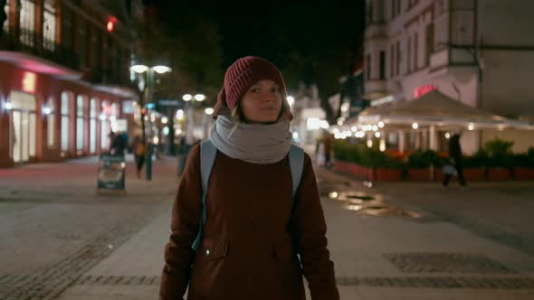 Portrait of Happy Woman Walking and Smiling To Camera in Street at Cold Night