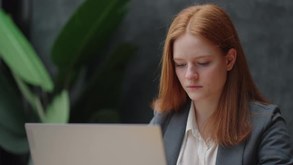 Woman Office Worker is Sitting at Table with Laptop and Communicating in Online Chat alt