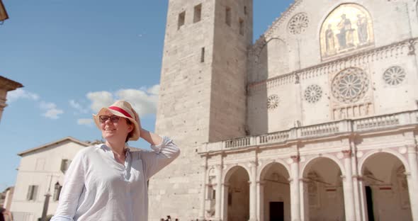 Traveler woman in hat sightseeing antique cathedral in Italy