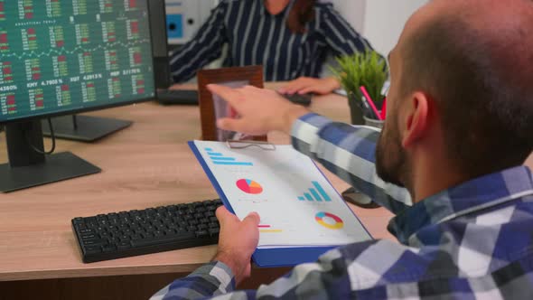 Young Employee Checking Clipboard Information alt