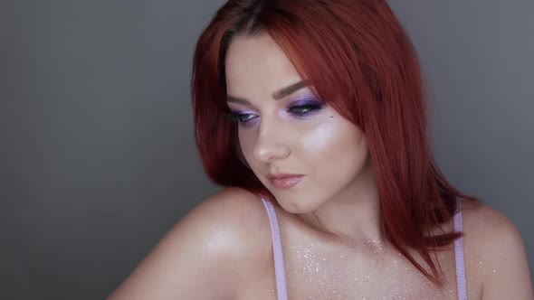 Closeup View of Beautiful Young Girl Model with Bright Red Hair and Purple Makeup Posing in the alt