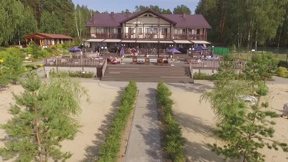 Modern country recreation center with a pool. People relax, swim and lie 05 alt