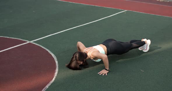 Athletic Young Woman Is Training Doing Push-ups on Stadium in College Campus