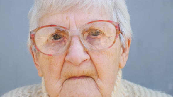 Portrait of Old Lady in Eyeglasses with Pensive Sight alt