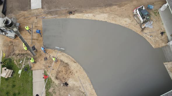 Birds eye view of concrete crew putting the finishing touches on a new driveway at fast pace.