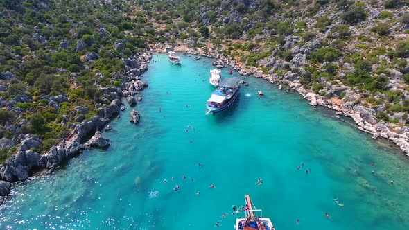 Diving Tour Boats Anchored in a Small Bay in Turkey and Tourists Vacationers Swimming in the Sea alt