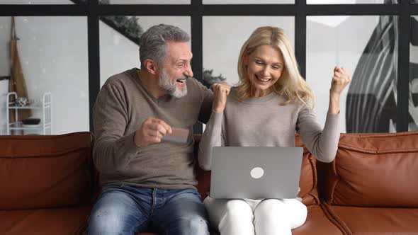 Cheerful Middleaged Couple Using Laptop for Making Purchases in Online Shopping alt