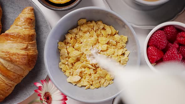 Milk Pouring Into Bowl Full of Corn Flakes with Splashing alt