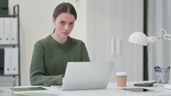 Young Woman with Laptop Shaking Head in Denial alt