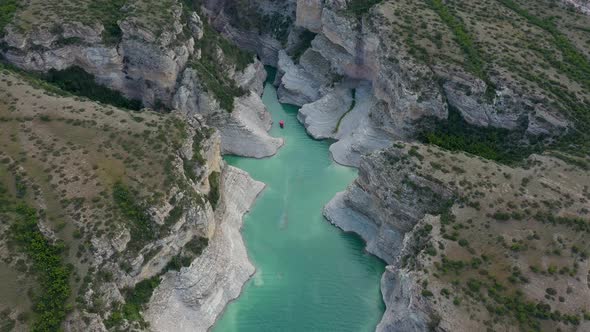Top view of a mountain river in the canyon and  boat sailing along a turquoise river among the rocks