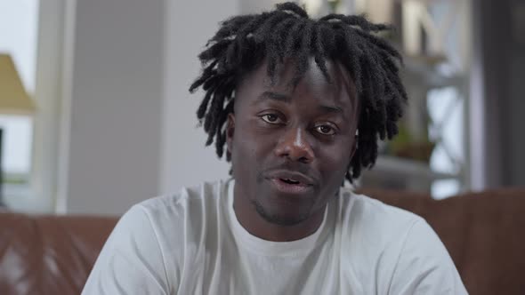 Web Camera POV of African American Young Man Talking in Slow Motion Sitting at Home Indoors alt