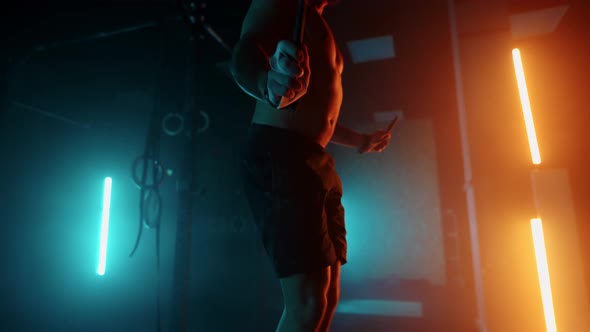 Sporty Man is Training in Gym Alone in Night Skipping Rope for Training Endurance and Strength alt