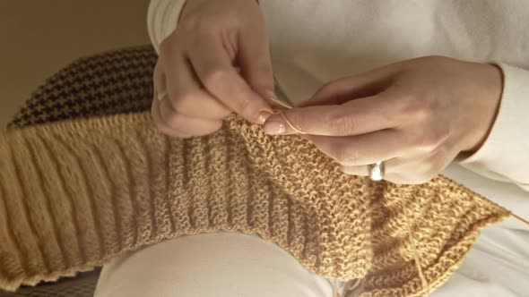 Womens Hands are Knitted with Needles on a Sunny Day