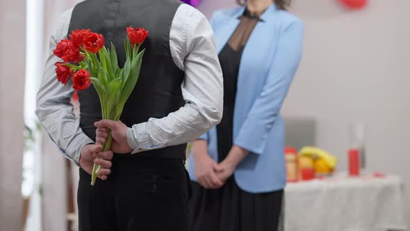 Back View of Nervous Adult Caucasian Man Holding Bouquet of Tulips Gift on Valentine's for Blurred alt