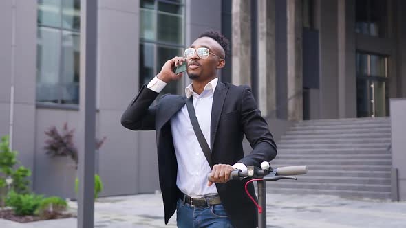 Modern Dark-Skinned Guy in Stylish Clothes and Sunglasses which Talking on Phone alt