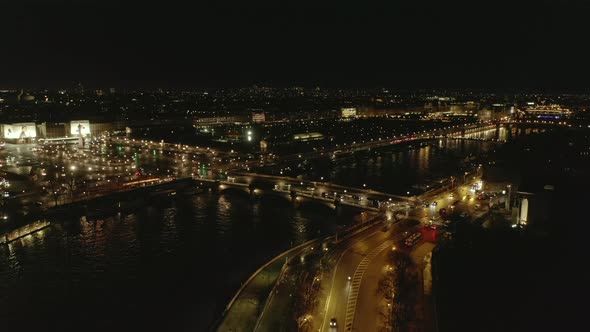 AERIAL: View Over Seine River in Paris, France at Night with Shining City Lights  alt