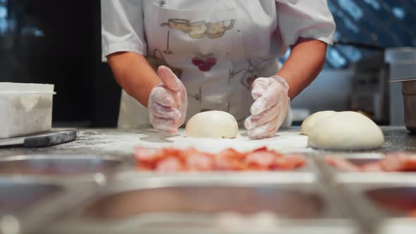 Cooking Pizza In A Pizzeria Restaurant, Chef Kneads And Rolls Out Pizza Dough Before Topping Filling alt