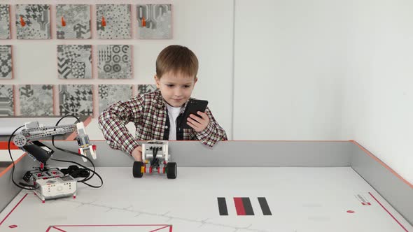 Little Boy Controls a Robot Using His Phone in a Robotics Class