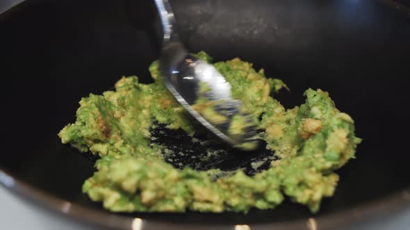 Guacamole dip sandwiches making, squeezing avocado using kitchen fork alt