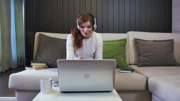 Young Smiling Laughing Lady Student Wearing Headphones Communicating By Video Call alt