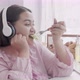 Young asian woman fat eating salad food and wearing headphone for listening music with delicious. - VideoHive Item for Sale