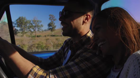 Young couple on a road trip in their pick-up truck alt