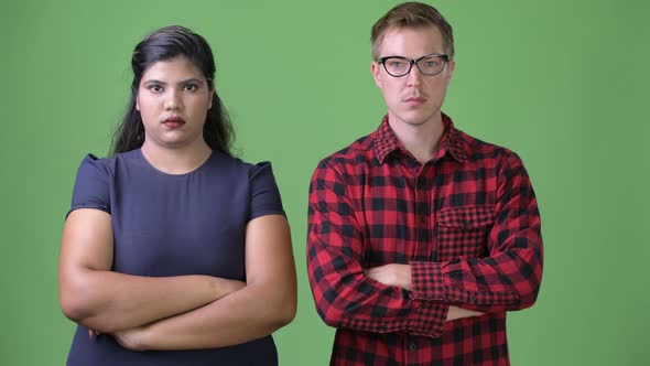 Young Multi-ethnic Business Couple Together Against Green Background alt