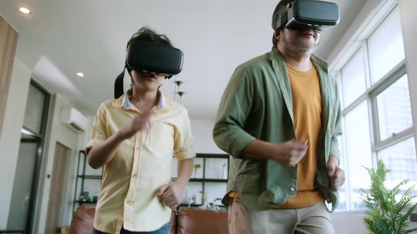Dad and son wear VR or virtual reality glasses,headsets standing and playing a video game