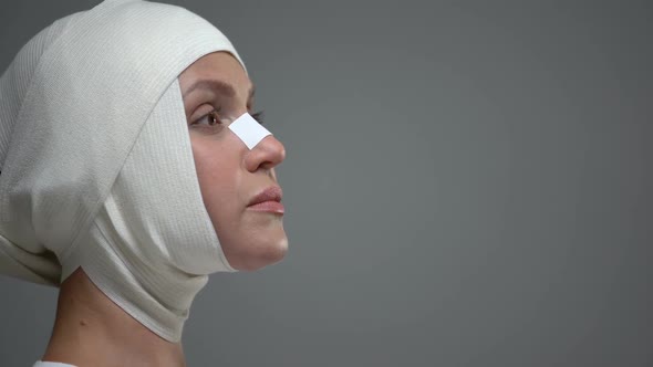 Woman in Headwrap Standing on Grey Background, Skull Injury, Accident Result