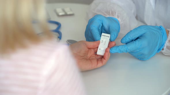 Doctors Hands Give Rapid Antigen Test for Covid19 and Pills to Patient in Clinic alt