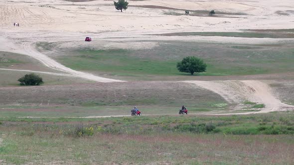 People Riding Quadbikes in spring off-road fields