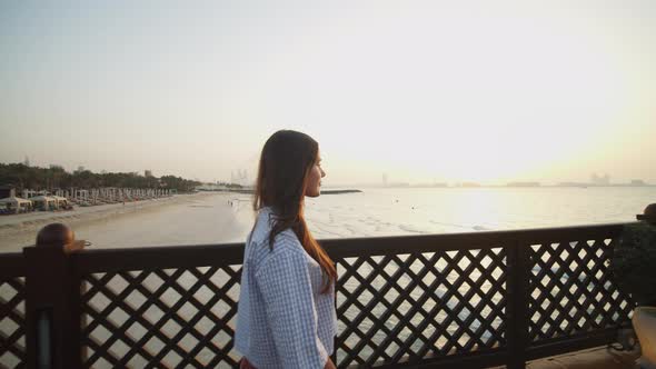 Woman Walking on the Pier During Sunset alt