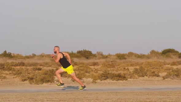 Runner Athlete Practising Sprinting on Dirt Road on Sunny Day
