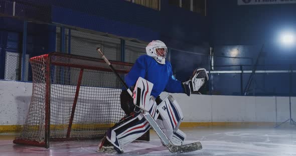 Hockey Player Conducts an Attack on the Opponent's Goal. Lying in a Helmet Catches the Puck alt