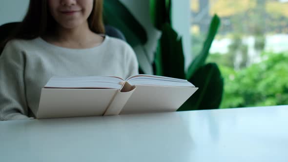 Closeup of a young asian woman reading book