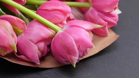 Pink Tulips in Kraft Paper on Black Background alt