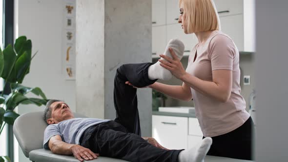 Female physical therapist working with senior man. Shot with RED helium camera in 8K. alt