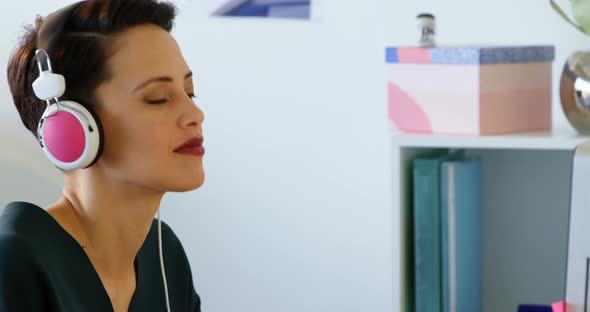 Side view of Caucasian Businesswoman in headphones working on computer at desk in office 4k