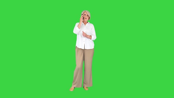 Senior Woman with Smartphone Making a Call on a Green Screen Chroma Key alt