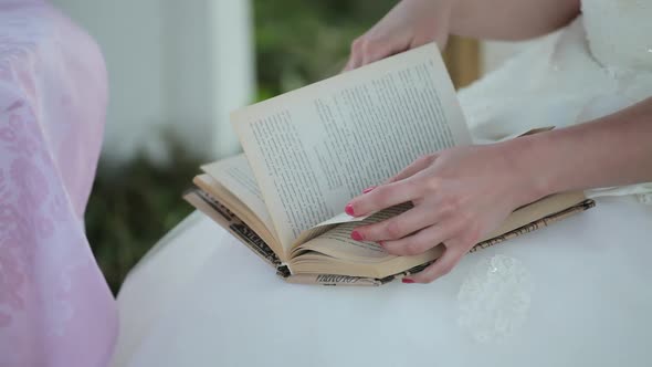 a girl in a white dress reads a book alt