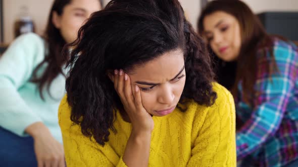 Black Woman Feeling Depressed While Roommates Gossiping Behind Her Back alt