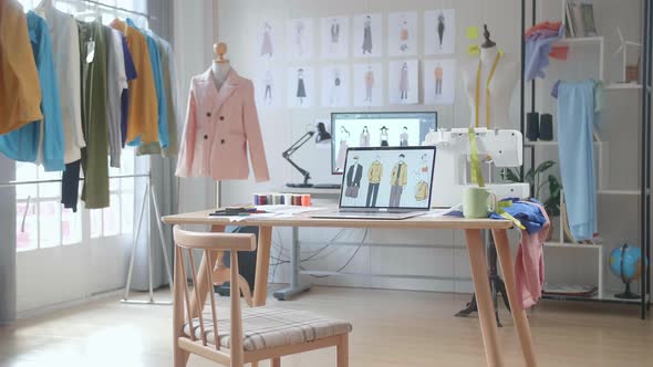 A Laptop Is On The Table Showing Clothes Pictures In The Designer Studio alt