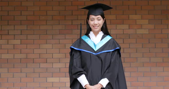 Asian woman get graduation gown alt