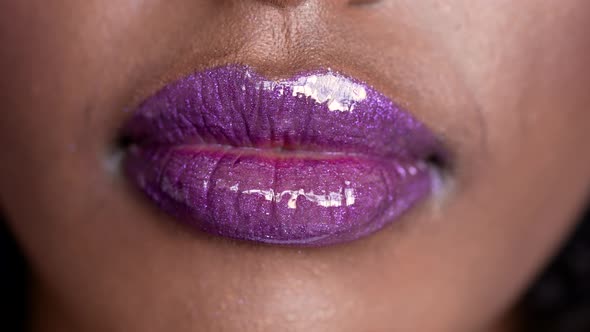 Close Up Shot on Purple Glowing Wet Makup Lips of Beautiful African Fashion Model