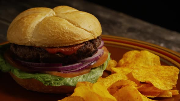 Rotating Shot of Delicious Burger and Potato Chips alt