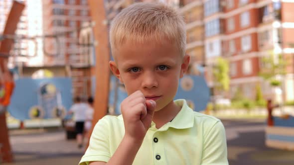 A Little Boy on a Modern Playground Playing the Game Rock Paper Scissors alt