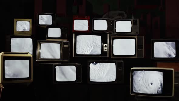 Satellite View, Hurricane seen from Space on a Pile of Vintage TV. alt