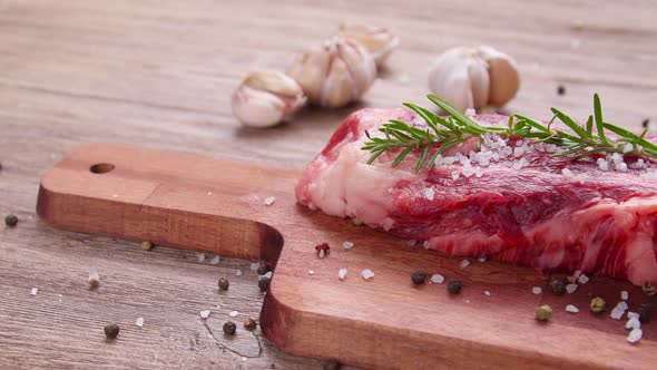 Raw Beef Steak on a Wooden Table alt