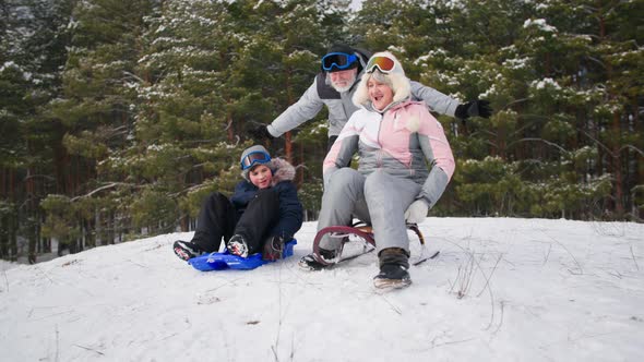 Winter Activities Loving Grandmother and Grandfather Together with a Male Child Have Fun Sledding